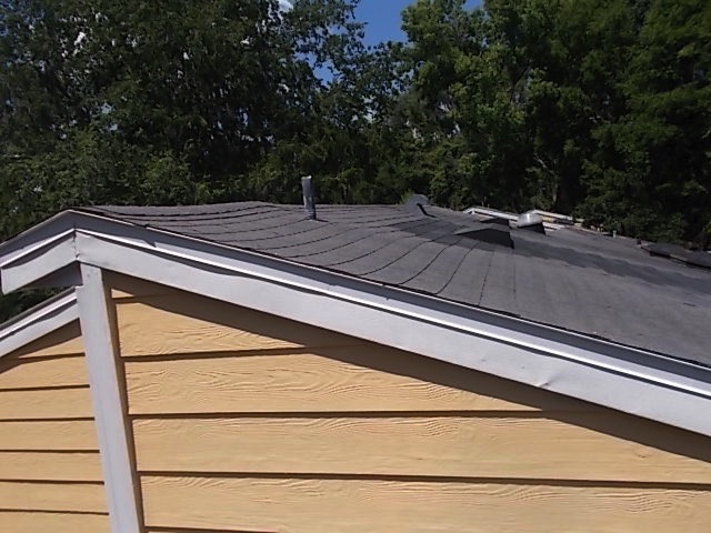 sagging roof with displaced shingles