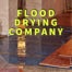 Flood drying company written in yellow over water damaged hardwood floors