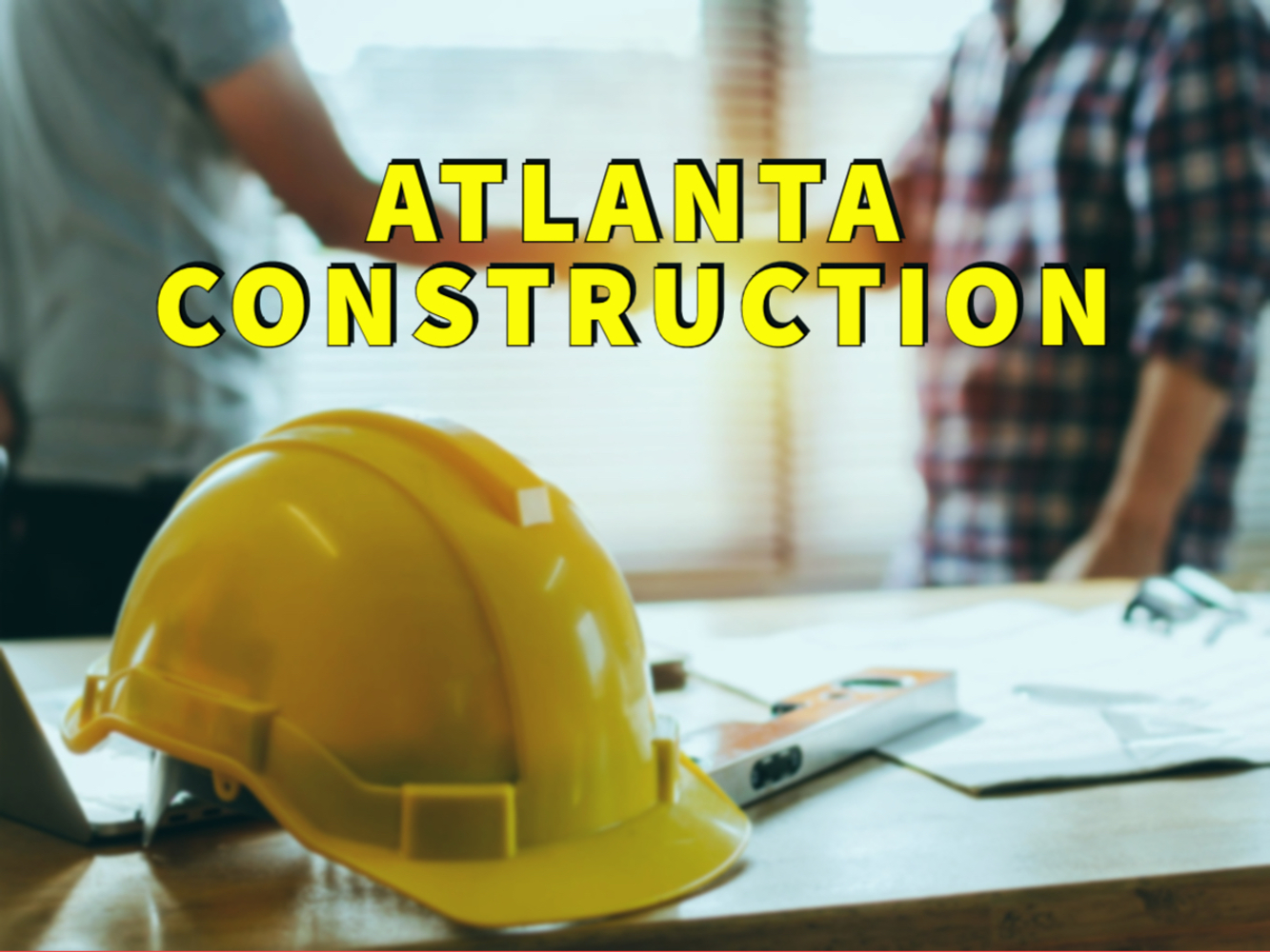 Atlanta construction written in yellow over two people shaking hands with construction hat in foreground