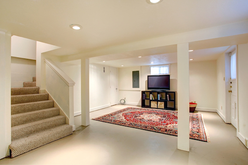 finished basement remodel showing stairs on the left with tv and entertainment center