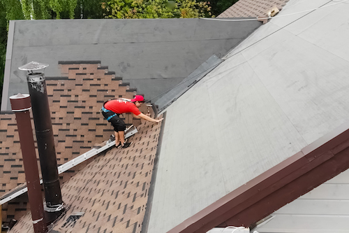 overhead shot of worker laying shingles during an atlanta roof repair