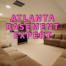 Atlanta basement expert written in pink over finished basement with tv over fireplace and tan couches