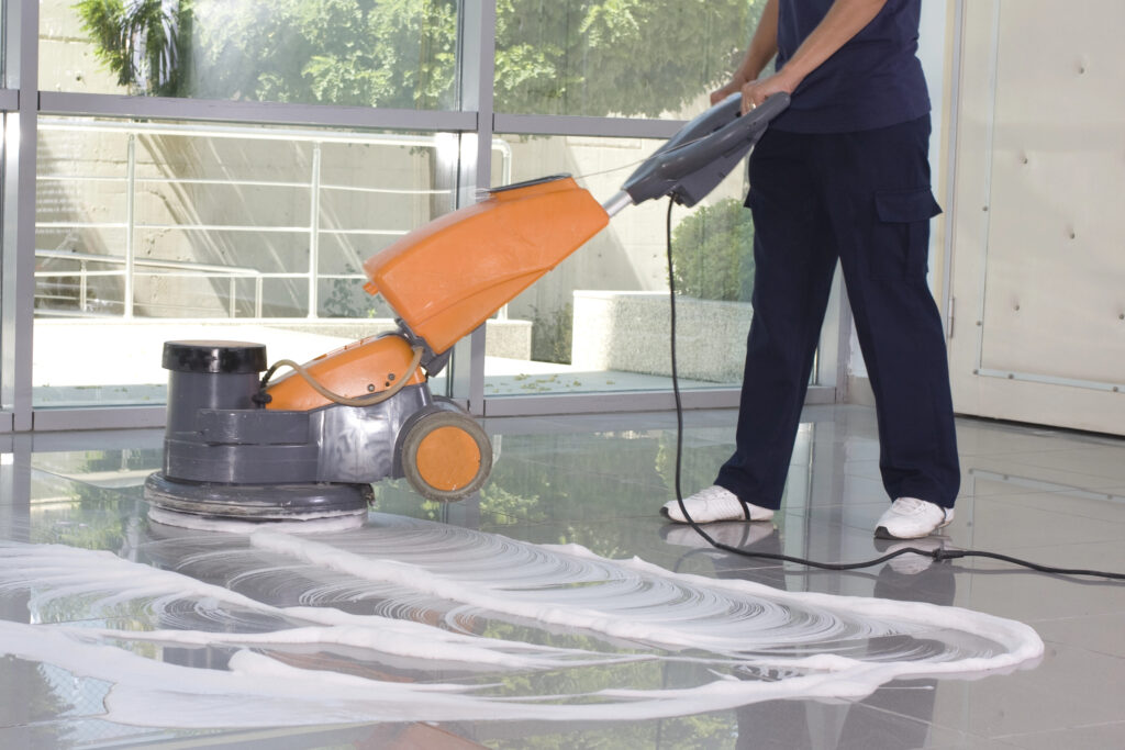 worker cleaning recent Atlanta commercial flooring installation with circular buffing machine